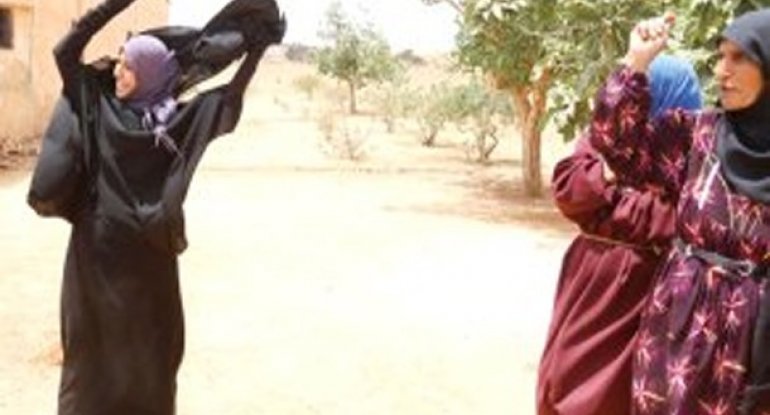 İŞİD-dən azad edilən ərazilərdə qadınlar çadralarını çıxarıb atırlar